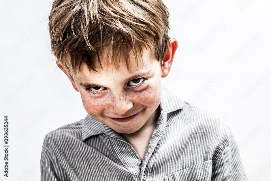 playful boy smiling, looking mischievous for shy child humour фотография Stock | Adobe Stock
