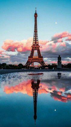 Пін може містити: the eiffel tower is reflected in the water at dusk with pink clouds behind it