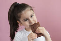 Cute child girl eating chocolate. Pretty child with chocolate. Stock Photo | Adobe Stock