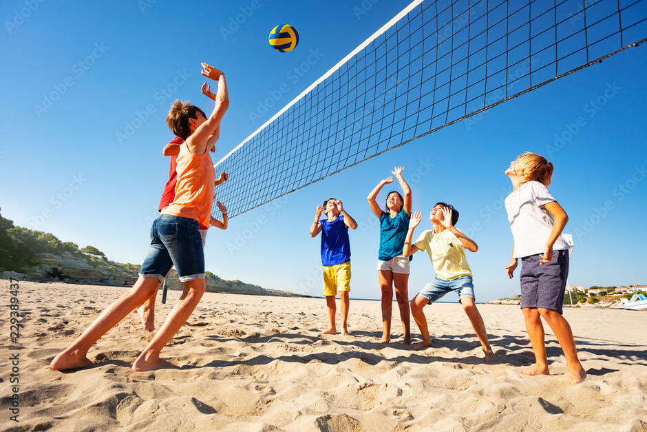 Boys and girls playing volleyball on the beach Фотографія Stock | Adobe Stock